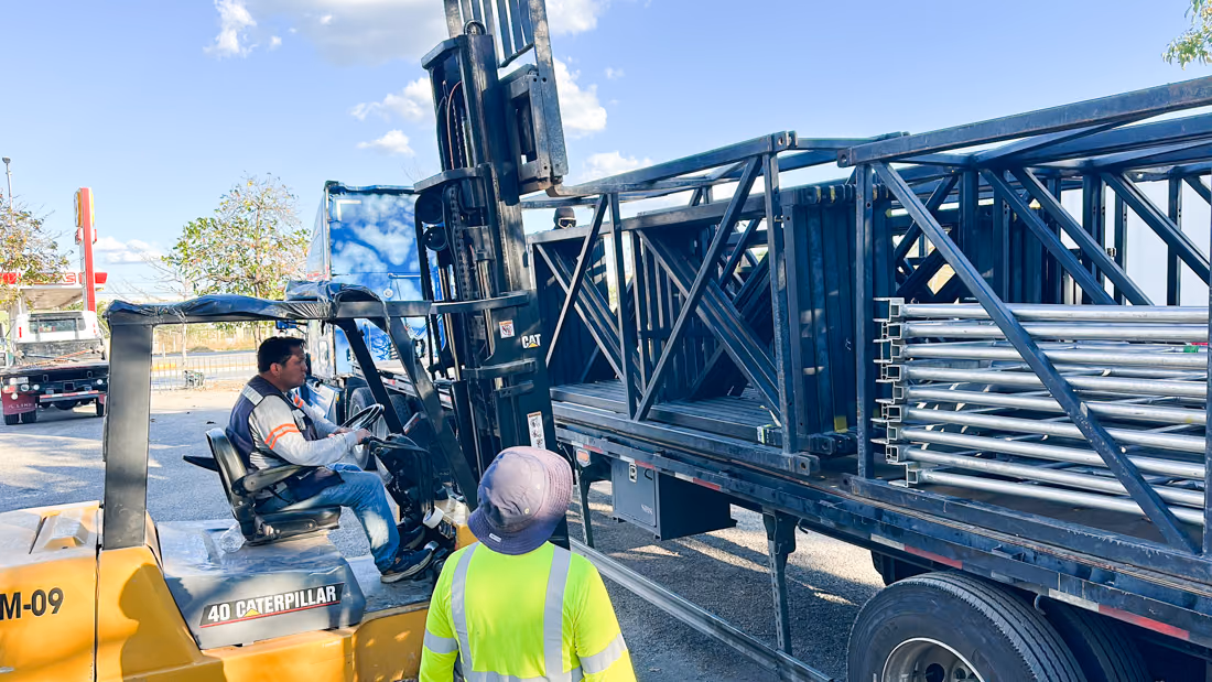 Crew de Fermatta cargando tramos de truss a un camión con montacargas