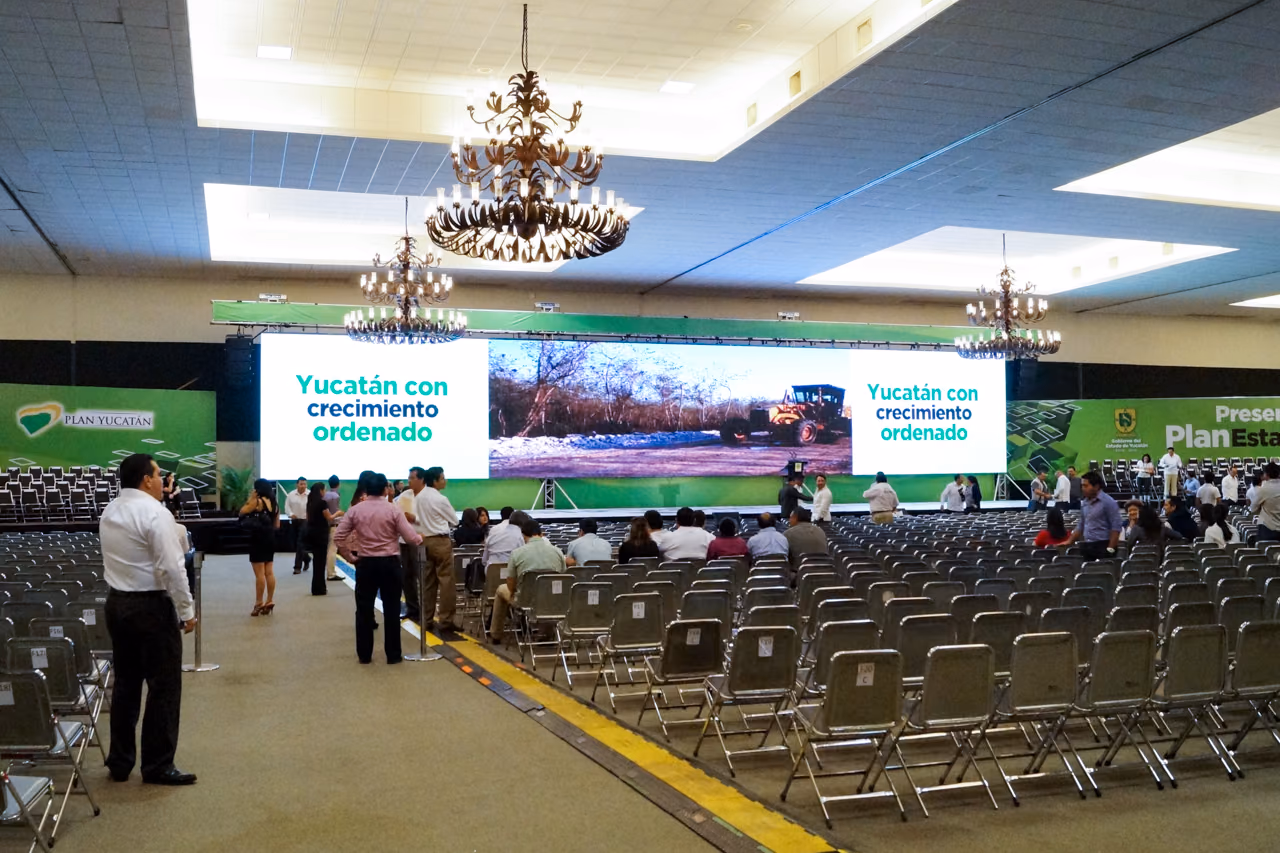 Salón de congreso montado con pantallas LED y escenario para un evento gubernamental